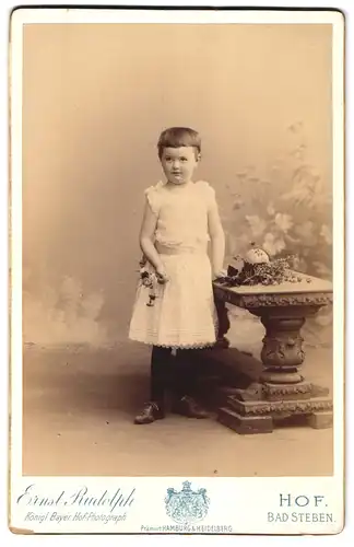 Fotografie Ernst Rudolph, Hof, Marien-Strasse 69, Portrait kleines Mädchen im weissen Kleid in einer Studiokulisse