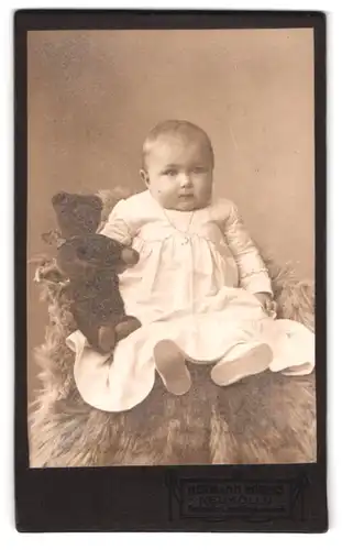Fotografie Hermann Böbers, Berlin-Neukölln, Saalestr. 1, Baby im Taufkleid mit Teddybär