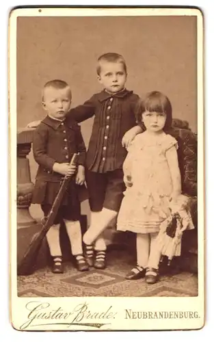 Fotografie Gustav Brade, Neubrandenburg, Knabe mit Gewehr & Mädchen mit Puppe
