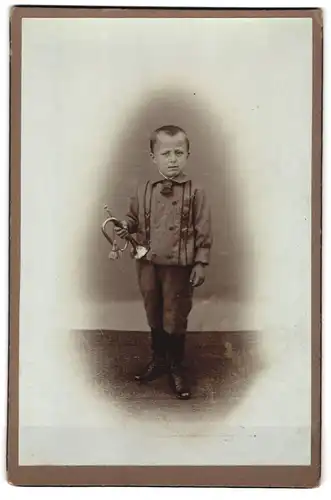 Fotografie unbekannter Fotograf und Ort, Knabe mit Trompete beim Fotograf