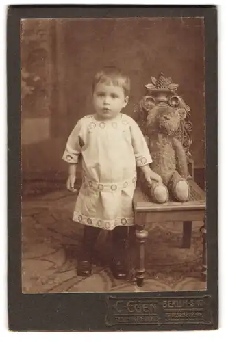 Fotografie C. Euen, Berlin, Friesenstrasse 14, Kleinkind nebst Teddybär auf Stuhl sitzend