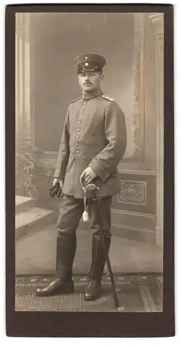 Fotografie unbekannter Fotograf und Ort, Leutnant in Feldgrau mit Säbel, Inf.-Rgt. 115