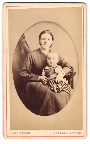 Fotografie Heinr. Strube, Löbau, Portrait bürgerliche Dame mit Kleinkind auf dem Schoss, Mutterglück