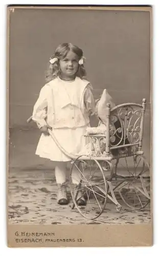 Fotografie G. Heinemann, Eisenach, Frauenberg 13, Portrait kleines Mädchen im Kleid mit Puppenwagen