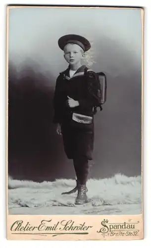 Fotografie Emil Schröter, Berlin-Spandau, Breitestrasse 32, Portrait Junge im Matrosenanzug mit Mützenband und Ranzen