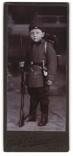 Fotografie Erich Schumpelt, Jessnitz / Anhalt, Knabe in Uniform mit Gewehr, Bajonett & Pickelhaube mit Überzug