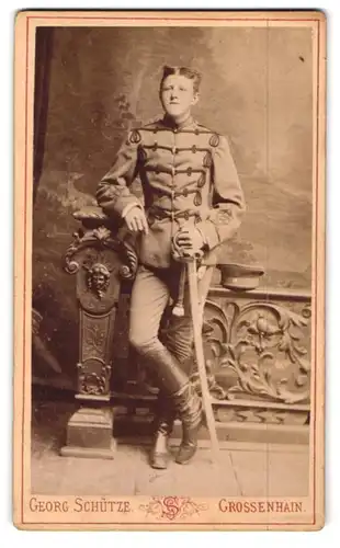 Fotografie Georg Schütze, Grossenhain, Johannes-Allee 64b, Husar in Uniform mit Säbel an Brüstung lehnend