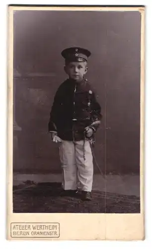 Fotografie Atelier Wertheim, Berlin, Oranienstrasse, Kleiner Soldat in Uniform mit Schirmmütze und Spielzeugsäbel