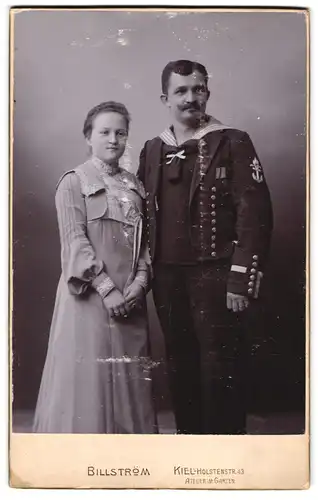 Fotografie Atelier Billström, Kiel, Holstenstr. 43, Matrose der kaiserlichen Marine in Uniform nebst Gattin