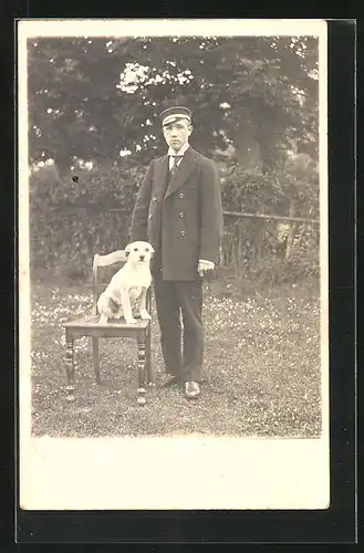 AK Junger Mann steht neben seinem Hund
