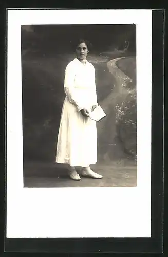 Foto-AK Junge Frau hält ein Buch in der Hand, Studiokulisse