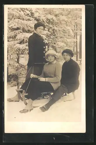 AK drei hübsche junge Frauen mit Schlitten im Schnee