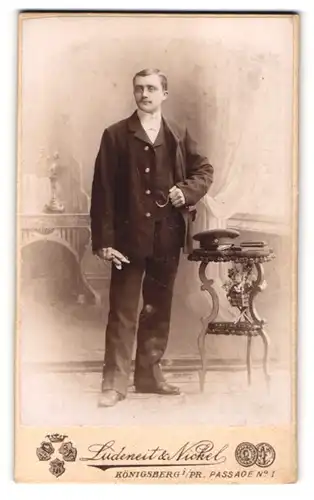 Fotografie Ludeneit & Nickel, Königsberg i. Pr., Chauffeur im Anzug mit Handschuhen nebst Schirmmütze