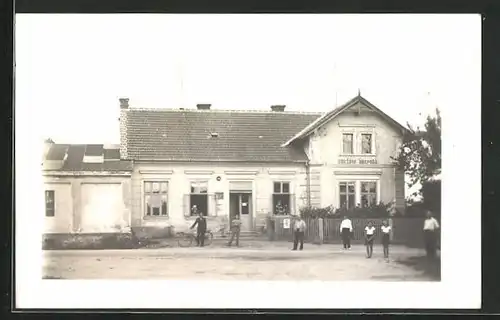 Foto-AK Miretice, Strassenpartie mit Gebäudeansicht