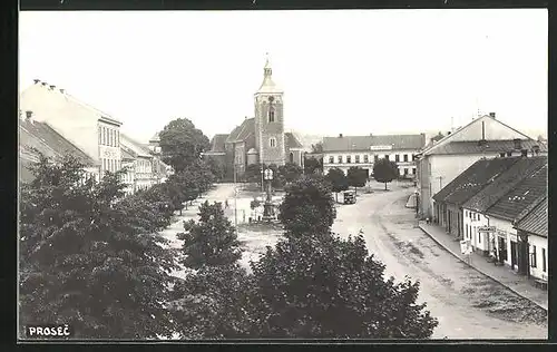 Foto-AK Prosec, Strassenpartie mit Kirche und Denkmal