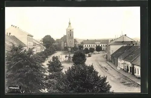 Foto-AK Prosec, Strassenpartie mit Kirche und Denkmal