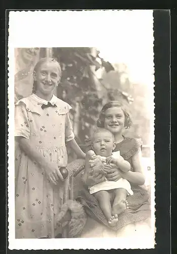 Foto-AK Geschwister mit Kleinkind und Puppe im Arm