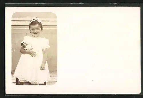 Foto-AK Kleines Mädchen im Kleid mit Puppe im Arm