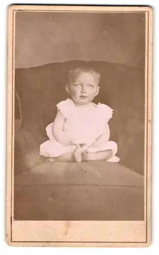 Fotografie unbekannter Fotograf und Ort, Portrait entzückendes Kleinkind im Hemdchen auf einem Sessel