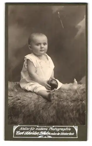 Fotografie Curt Schröder, Döbeln, Portrait Baby mit Kulleraugen und Ball auf einem Fell