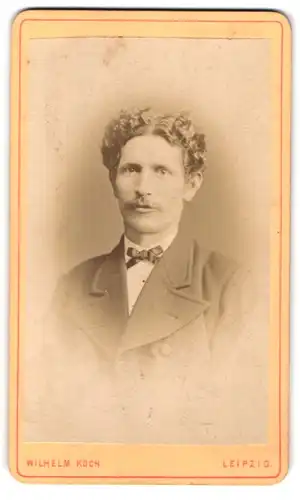 Fotografie Wilhelm Koch, Leipzig, Zeitzerstr. 41, Portrait junger Herr mit lockigem Haar und Fliege