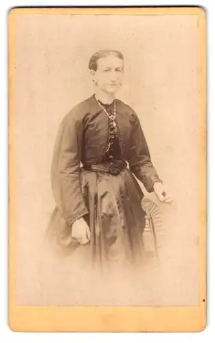 Fotografie Carl Grust, Meissen, Rothe Stufen 25, Portrait Dame mit Flechtfrisur und zeitgenössischem Kleid