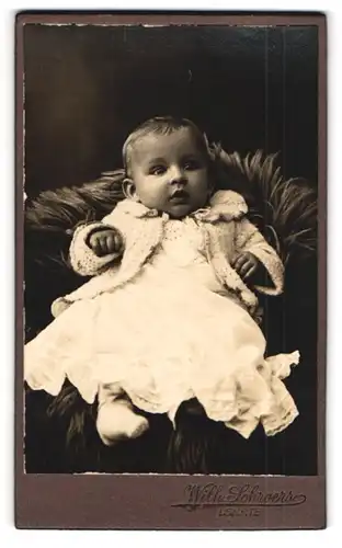 Fotografie Wilh. Schroers, Lehrte, Portrait niedliches Baby auf einem Fell