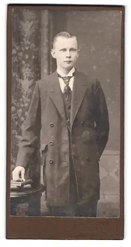 Fotografie Paul Dobrick, Döbeln, Bahnhofstrsse 71, Portrait eleganter junger Herr im Mantel und Krawatte