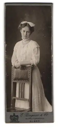 Fotografie E. Biegner & Co., Guben, Portrait junge Dame im Spitzenkleid mit Haarschleife