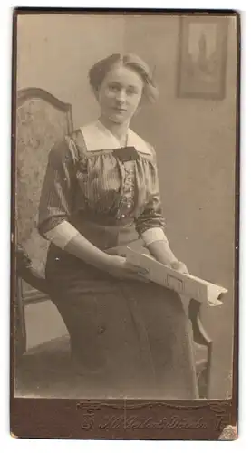 Fotografie F. O. Geilert, Döbeln, Portrait hübsche junge Frau sitzend mit Zeitschrift