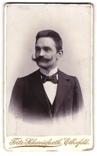 Fotografie Fritz Schweisfurth, Elberfeld, Portrait junger eleganter Herr mit Zwirbelbart und Fliege