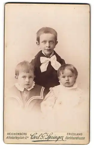 Fotografie Carl G. Springer, Friedland, Görlitzerstr., Portrait dreier niedlicher Kinder in Festkleidung