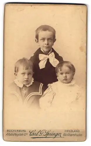 Fotografie Carl G. Springer, Friedland, Görlitzerstr., Portrait dreier niedlicher Kinder in Festkleidung