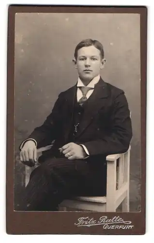 Fotografie Fritz Rutte, Querfurt, Portrait junger Mann im eleganten Anzug sitzend im Stuhl