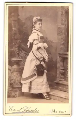 Fotografie Emil Schroeter, Meissen, Obergasse 597, junge Dame mit Haube & Umhängetasche trägt modisches Kleid