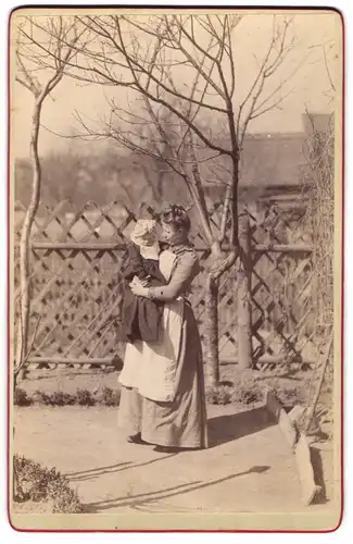 Fotografie Theodor Gläsche, Ostrau, Ansicht Ostrau i. S., Mutter mit Kleinkind im Arm spaziert durch ihren Garten