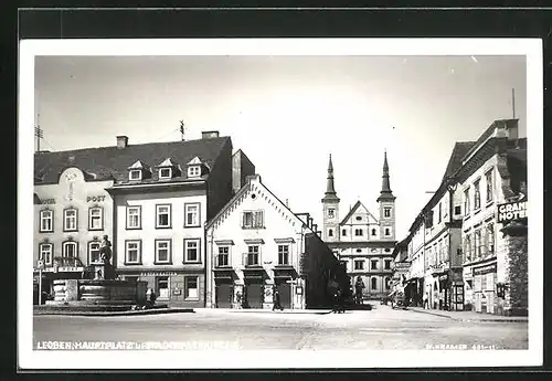 AK Leoben, Hauptplatz und Stadtpfarrkirche mit Grand Hotel, Hotel Post und Brunnen