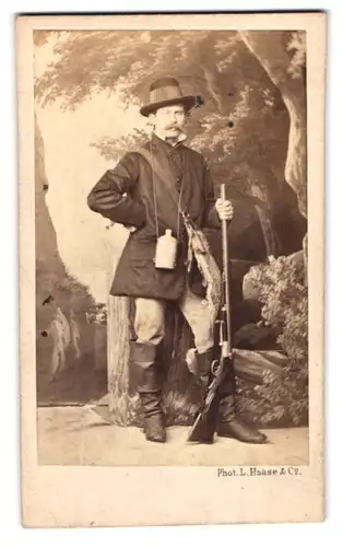 Fotografie L. Haase & Co., Breslau, Tauenzienstr. 10, Jäger mit Feldflasche und Gewehr