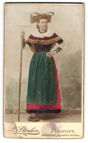 Fotografie P. Stecher, Pyrmont, Hauptallee, junge Dame mit Harke in Tracht, koloriert