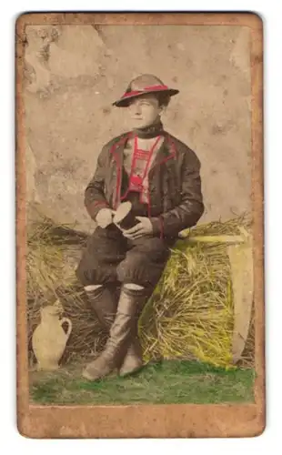 Fotografie unbekannter Fotograf und Ort, Bauernbursche mit Hut in Tracht, koloriert