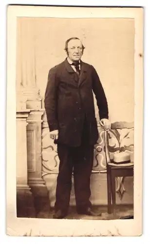 Fotografie unbekannter Fotograf und Ort, Portrait Herr im Anzug mit Krawatte posierend im Stuhl, 1864