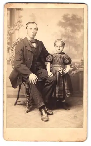 Fotografie Louis Strube, Altenburg, Portrait Vater im Anzug mit seiner kleinen Tochter im karierten Kleid