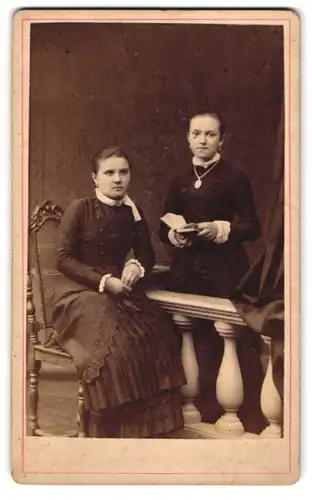 Fotografie unbekannter Fotograf und Ort, Portrait zwei junge Damen in dunklen Biedermeierkleidern mit Halskette