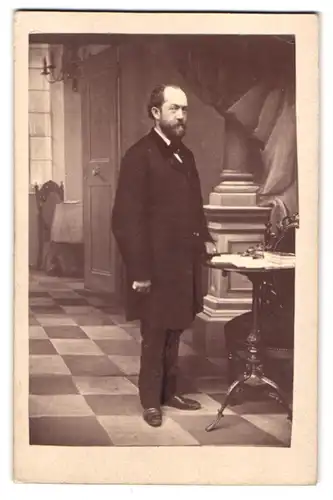 Fotografie J. Eberhardt, Nürnberg, Portrait Herr im Anzug mit Vollbart am Tisch stehend