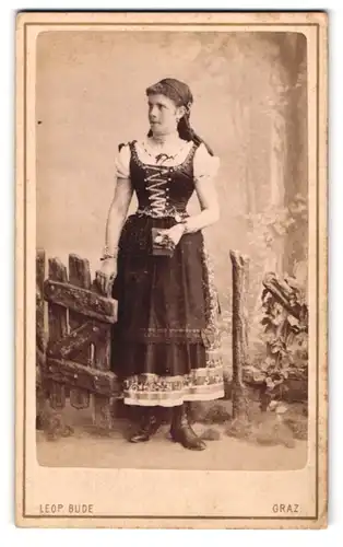 Fotografie Leop. Bude, Graz, Portrait junge Frau in Tracht mit Fotoalbum in der Hand