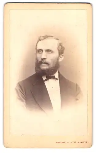 Fotografie Lutze & Witte, Berlin, Portrait Herr im Anzug mit Fliege und Backenbart