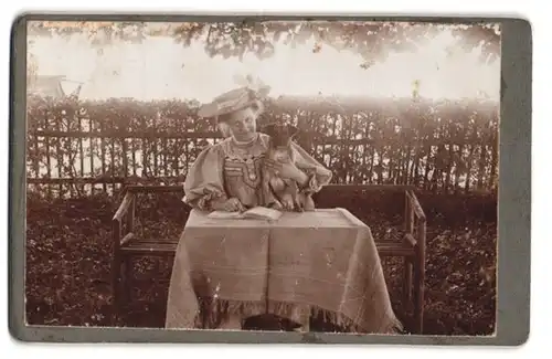 Fotografie unbekannter Fotograf und Ort, Portrait ältere Dame im Kleid mit ihrem Hund am Tisch sitzend