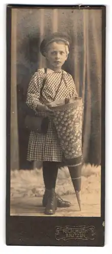 Fotografie Rich. Huth, Bautzen, Portrait niedliches Mädchen im karierten Kleid mit Zuckertüte und Ranzen, Schulanfang