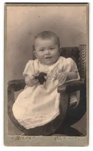 Fotografie M. Lange, Colditz i. S., Portrait niedliches Baby mit Puppe