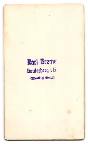 Fotografie Karl Breme, Lauterberg i. H., Portrait frecher Knabe mit Schiebermütze an einer Tür